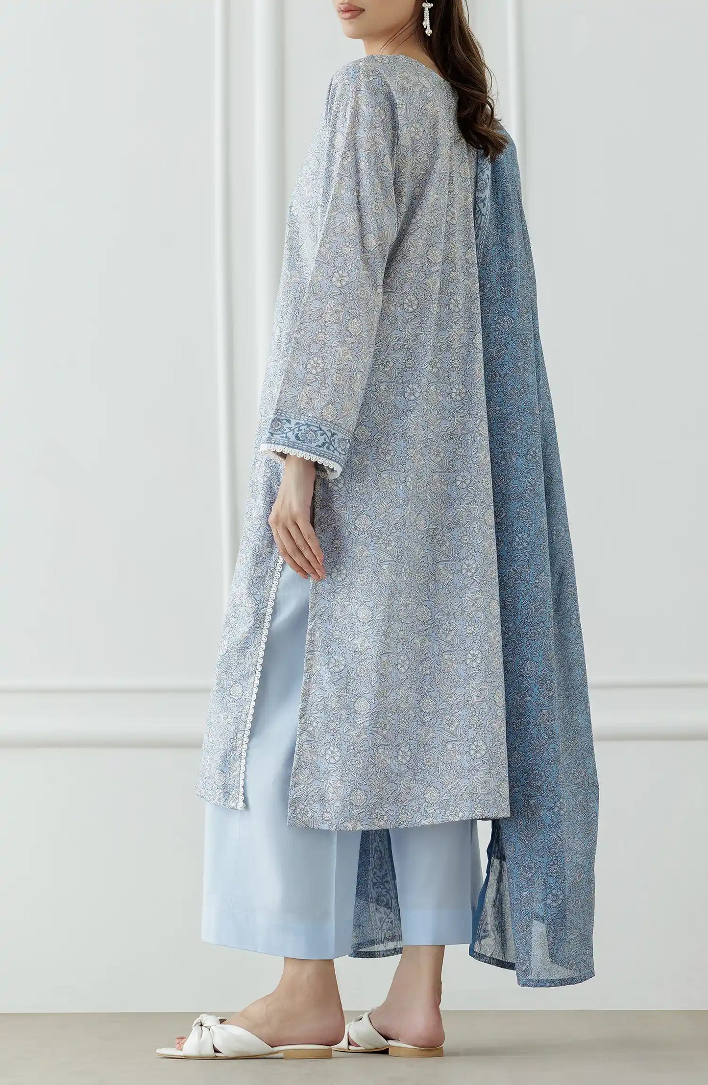 Woman wearing a light gray kurta with blue pants and a matching dupatta against a plain trouser. Stitched Printed Lawn Shirt Dupatta & Pant - 3 Piece Suits - OTL-25-018