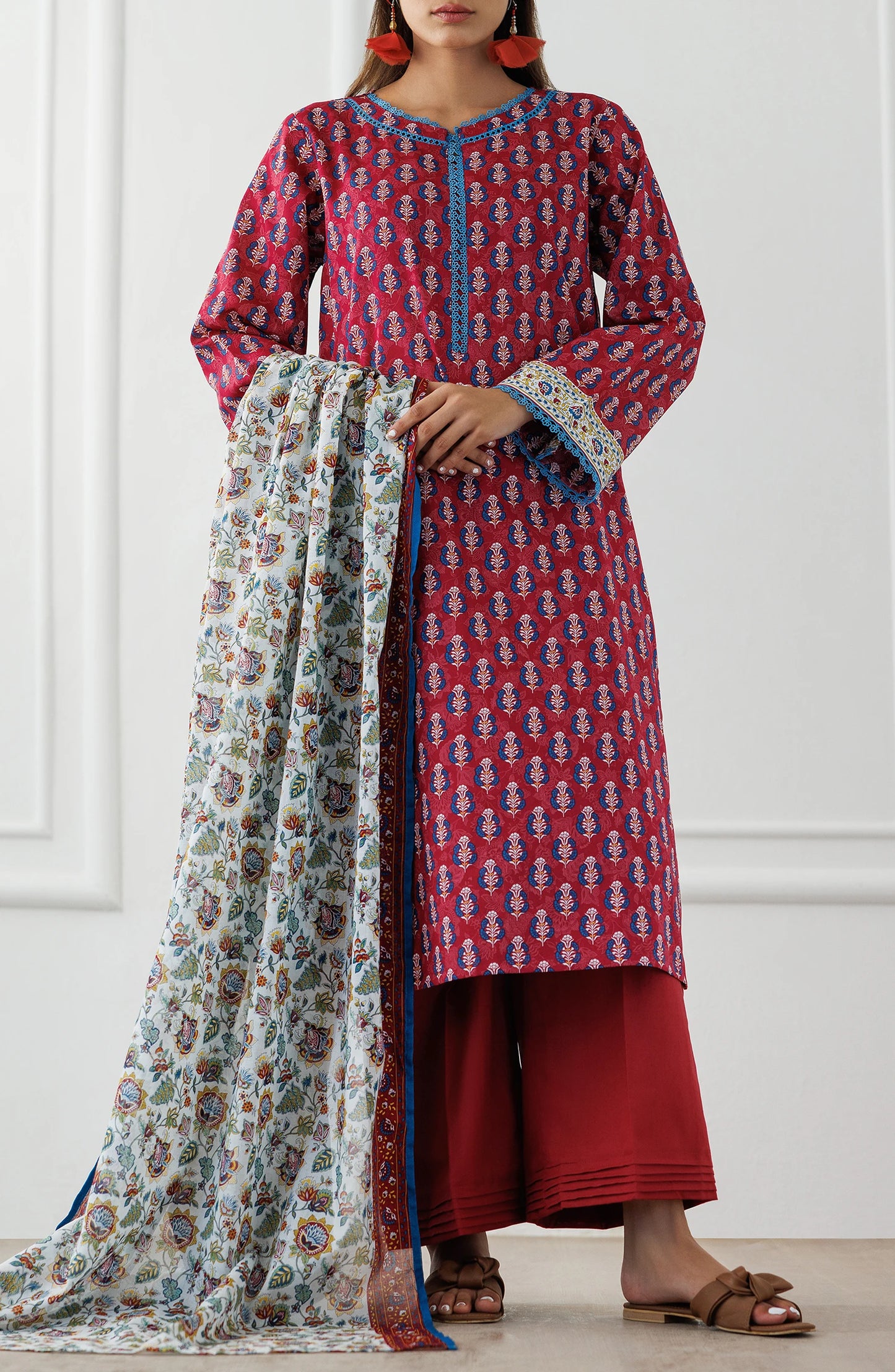 Woman wearing a red patterned kurta with a floral dupatta against a plain dyed trouser. Unstitched Printed Lawn Shirt Dupatta & Pant - 3 Piece Suits - OTL-25-063