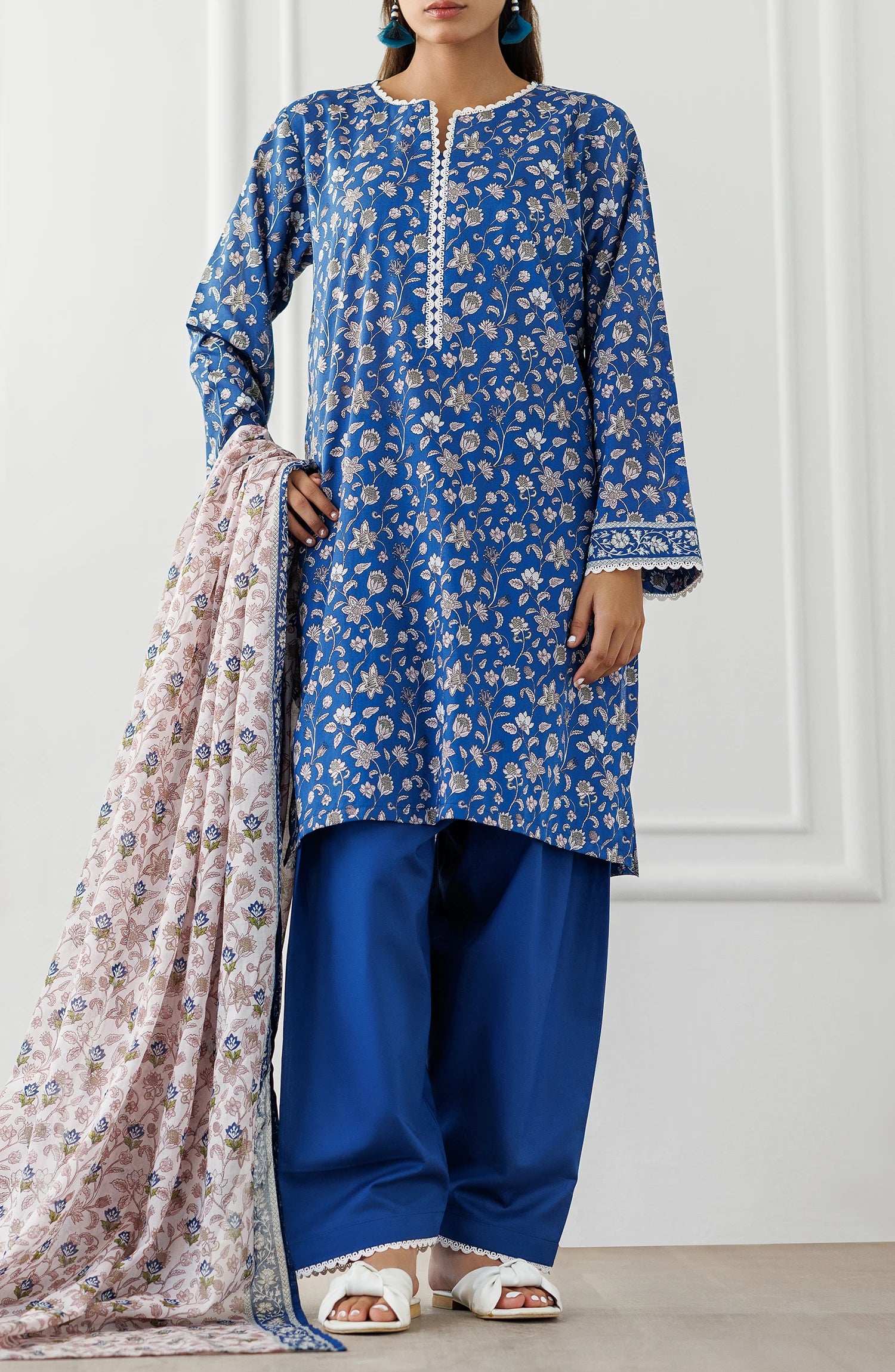 Woman wearing a blue floral kurta with matching pants and a pink dupatta against a dyed shalwar. Stitched Printed Lawn Shirt Dupatta & Pant - 3 Piece Suits - OTL-25-068