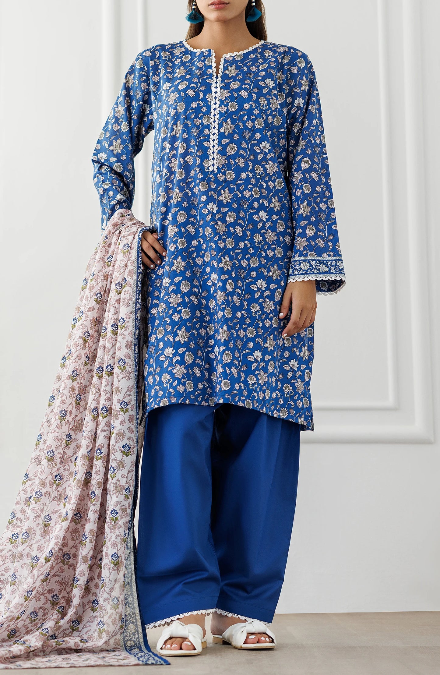 Woman wearing a blue floral kurta with matching pants and a pink dupatta against a dyed shalwar. Unstitched Printed Lawn Shirt Dupatta & Pant - 3 Piece Suits - OTL-25-068