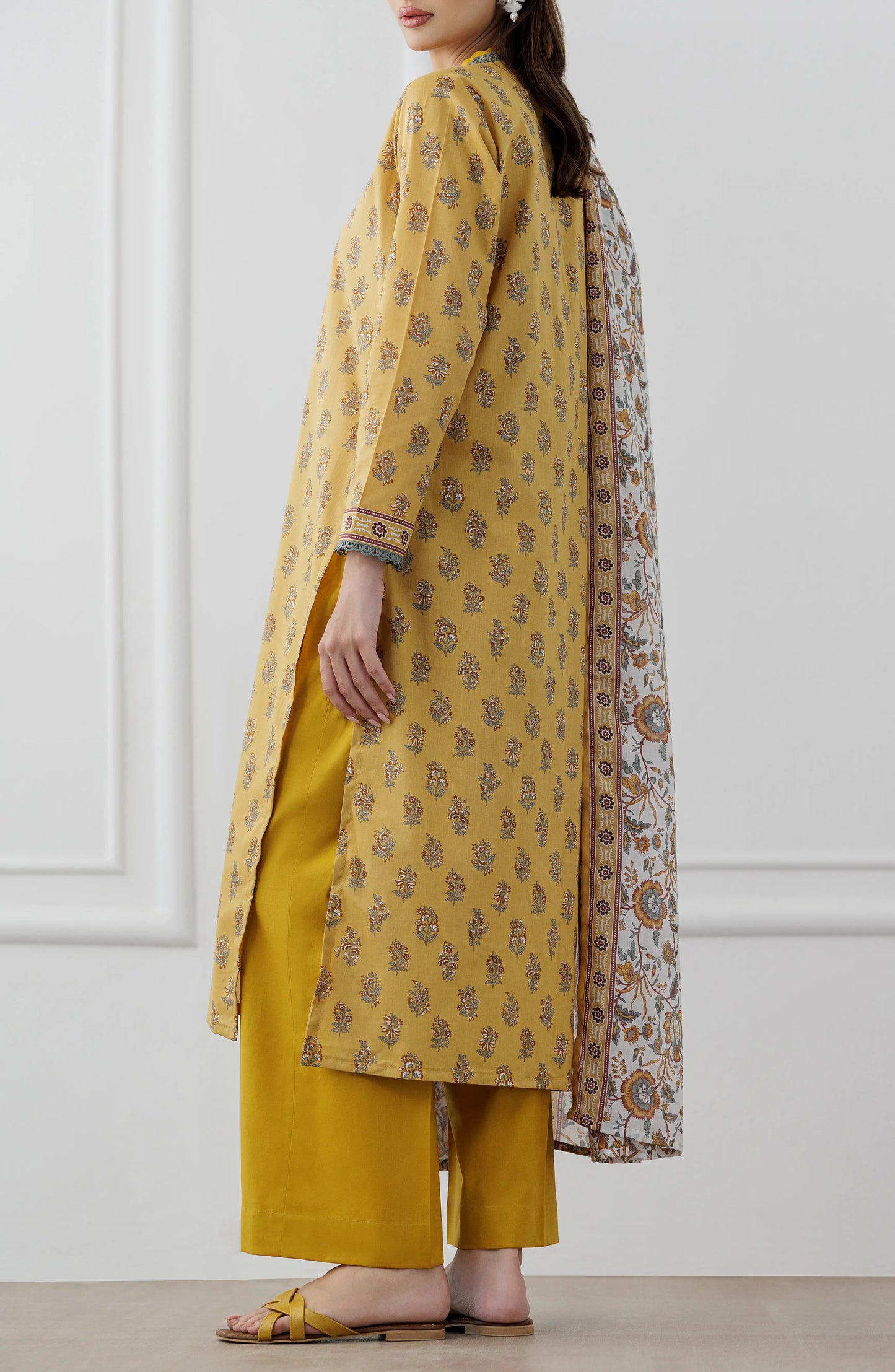 Woman wearing a mustard yellow floral dress with a matching dupatta on a plain trouser. Stitched Printed Lawn Shirt Dupatta & Pant - 3 Piece Suits - OTL-25-118