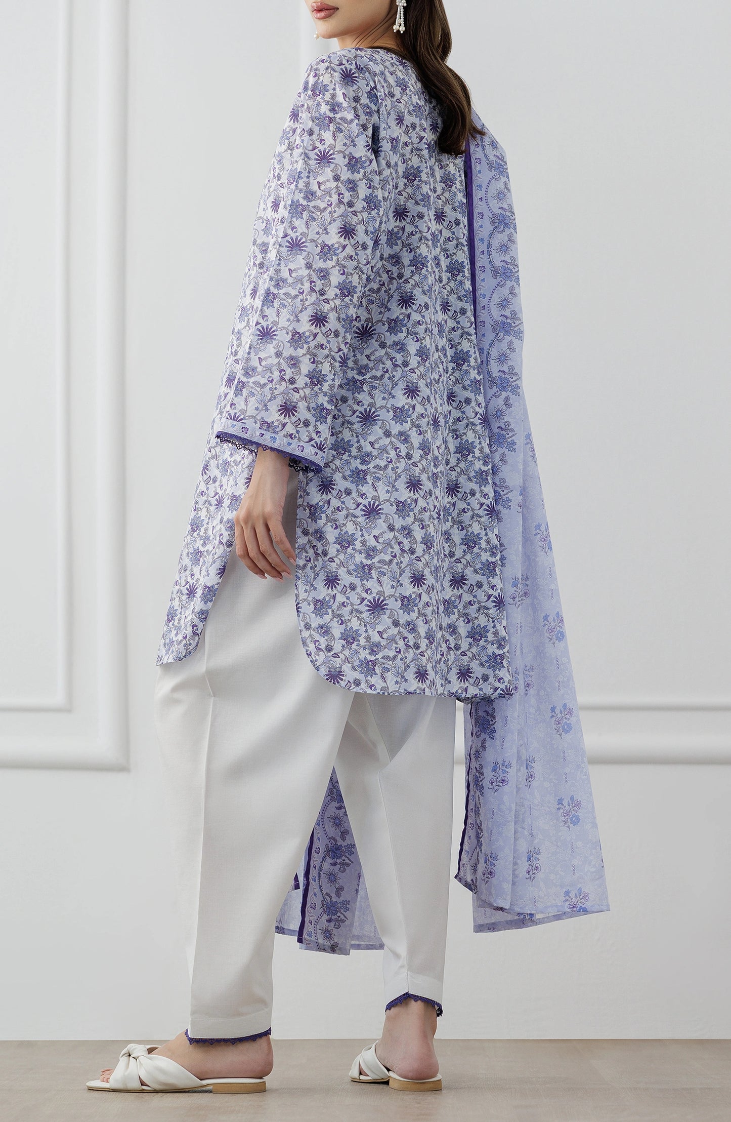 Woman wearing a floral kurta with white pants and a matching dupatta against a dyed trouser. Stitched Printed Lawn Shirt Dupatta & Pant - 3 Piece Suits - OTL-25-312