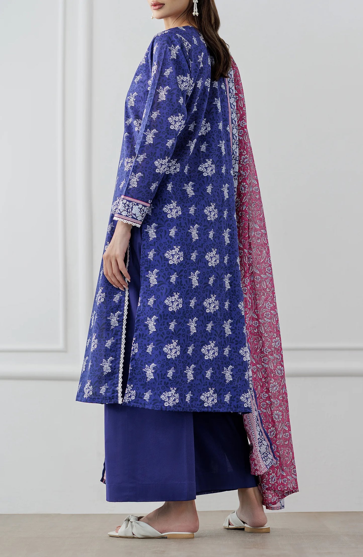 Woman wearing a blue floral dress with a pink dupatta against a plain trouser. Stitched Printed Lawn Shirt Dupatta & Pant - 3 Piece Suits - OTL-25-476