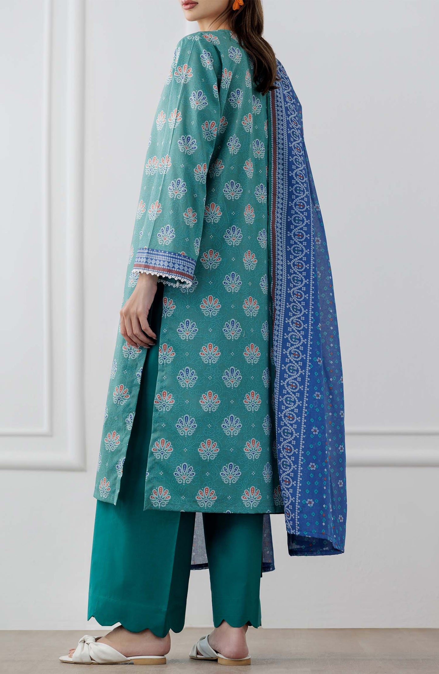 UNSTITCHED Printed Lawn Shirt Dupatta & Pant - 3 Piece Suits - OTL-25-307. Woman wearing a teal traditional outfit with a blue dupatta against a dyed trouser.