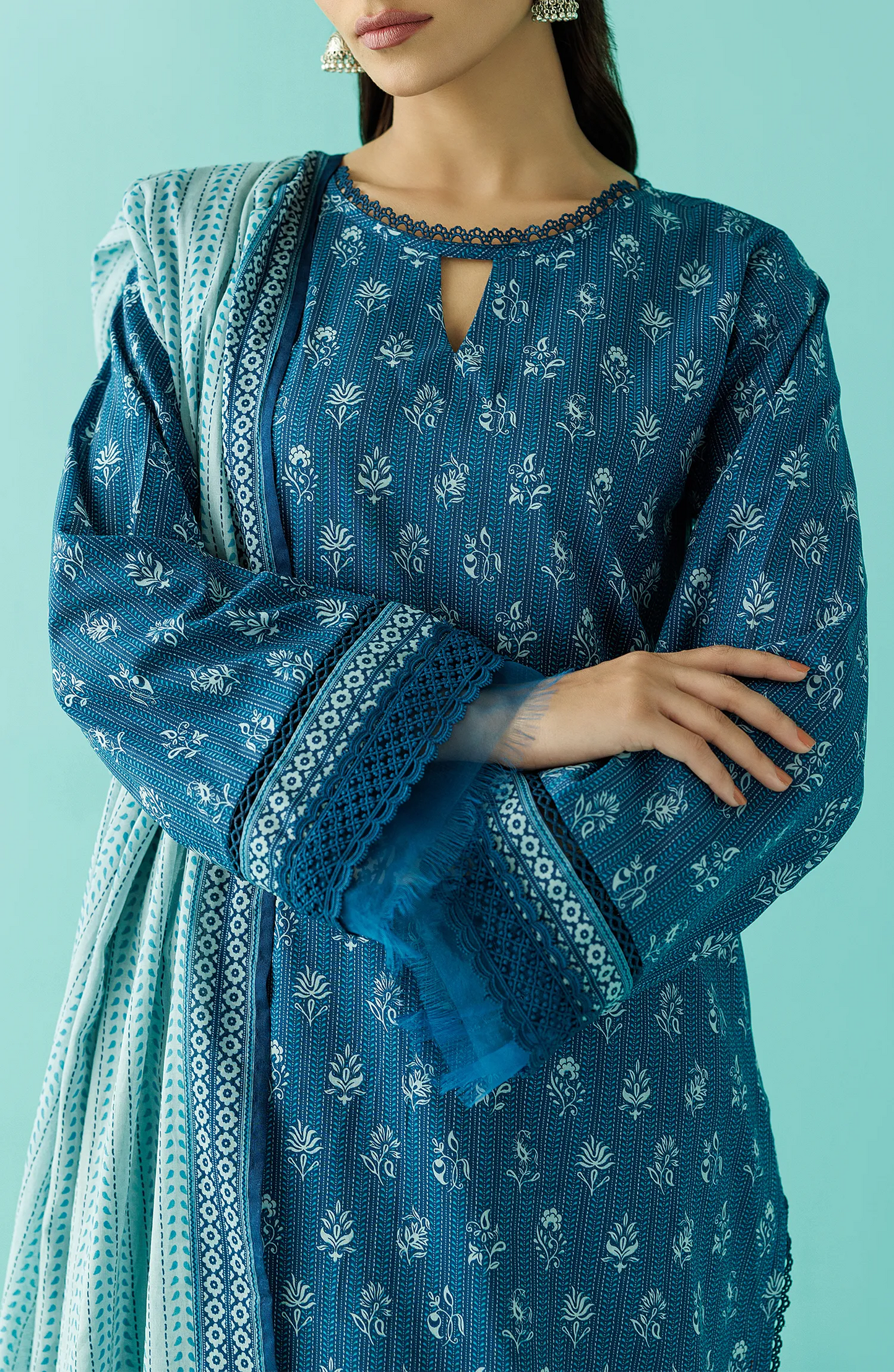 Woman wearing a blue traditional outfit with a matching dupatta against a teal blue shalwar. Unstitched Printed Lawn Shirt Dupatta & Pant - 3 Piece Suits - OTL-20045