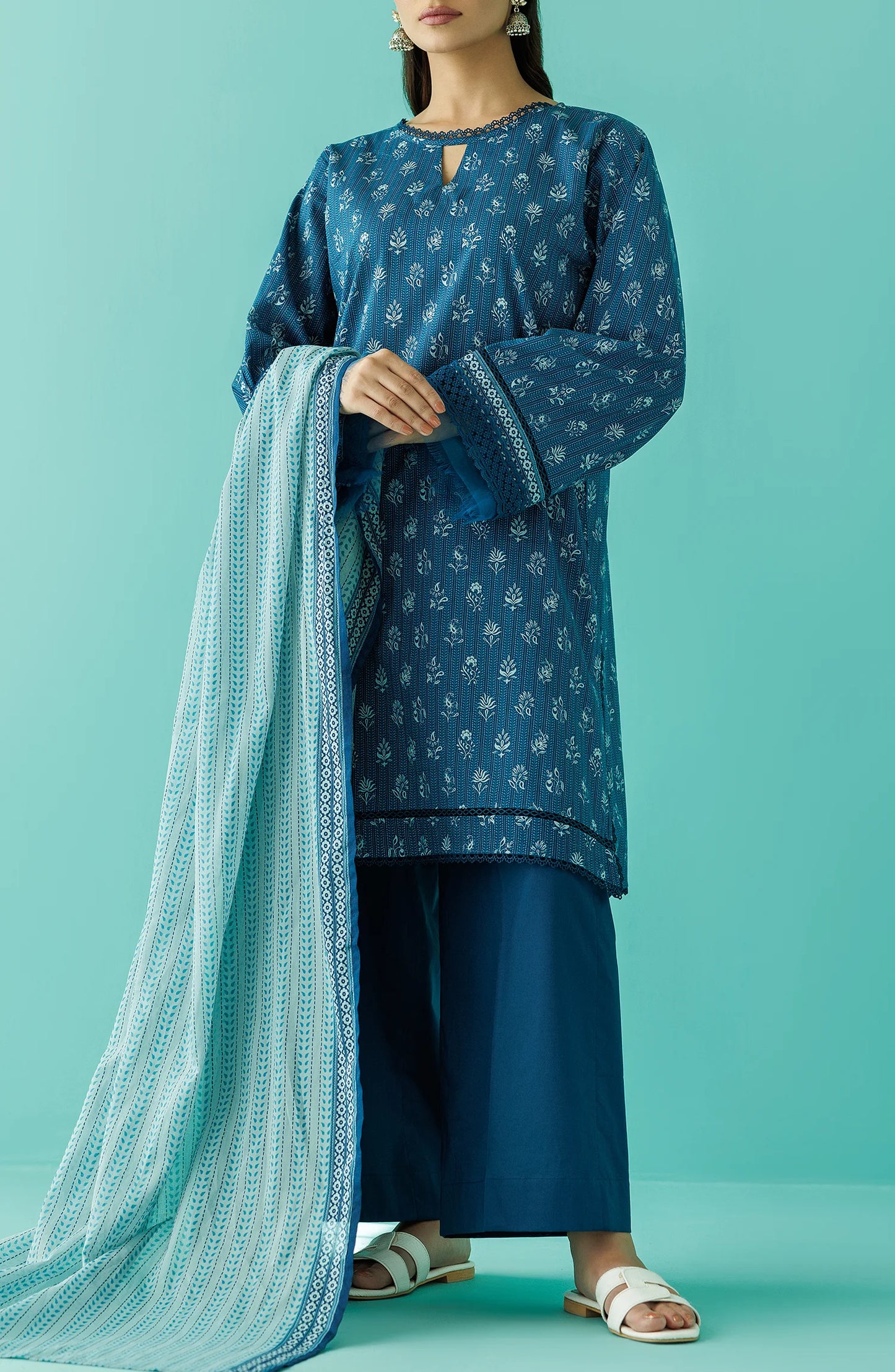 Woman wearing a blue traditional outfit with a matching dupatta against a teal blue shalwar. Unstitched Printed Lawn Shirt Dupatta & Pant - 3 Piece Suits - OTL-20045