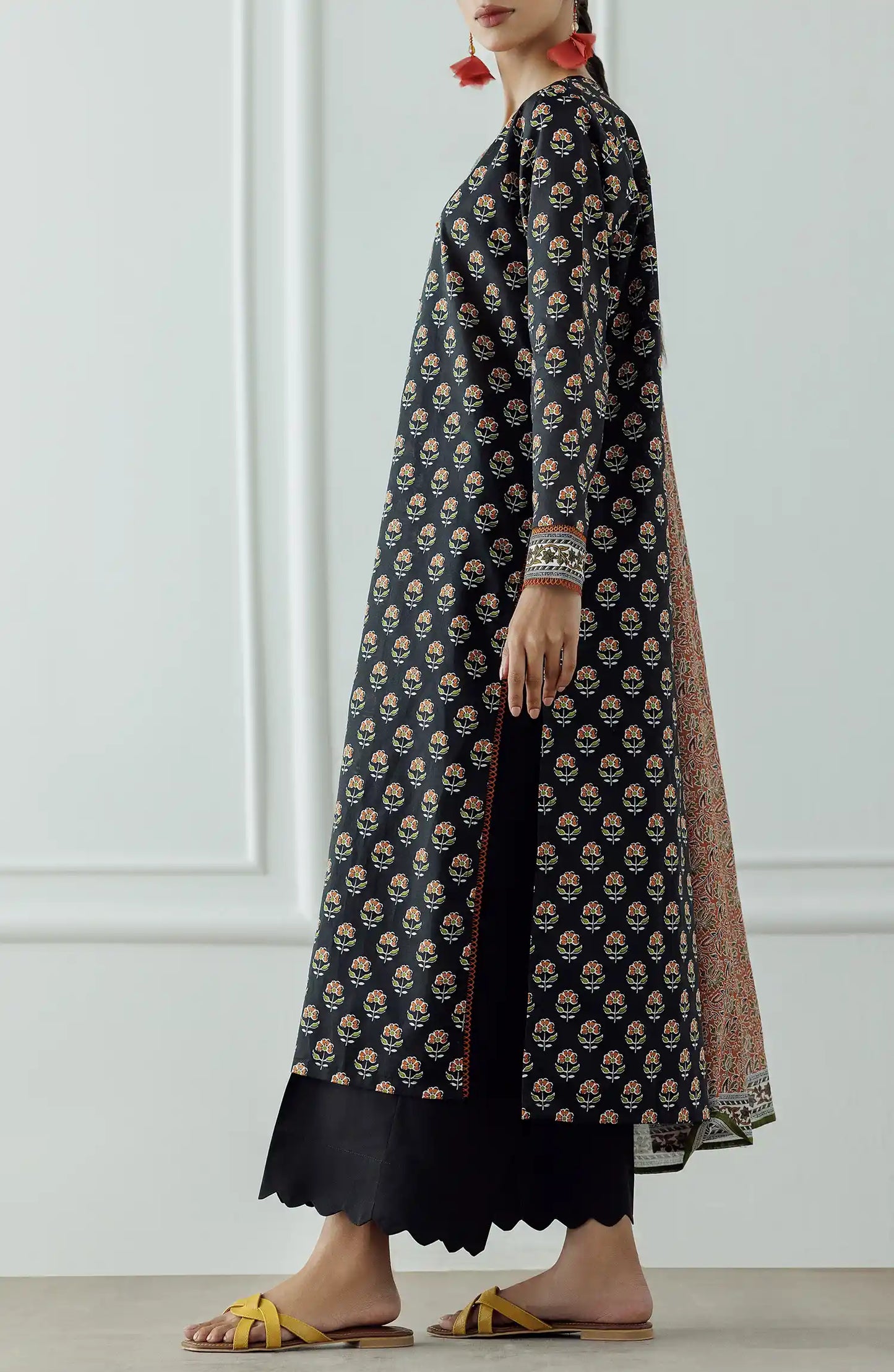 Woman wearing a black patterned kurta with a long dupatta against a black trouser. Stitched Printed Lawn Shirt Dupatta & Pant - 3 Piece - OTL-25-004.