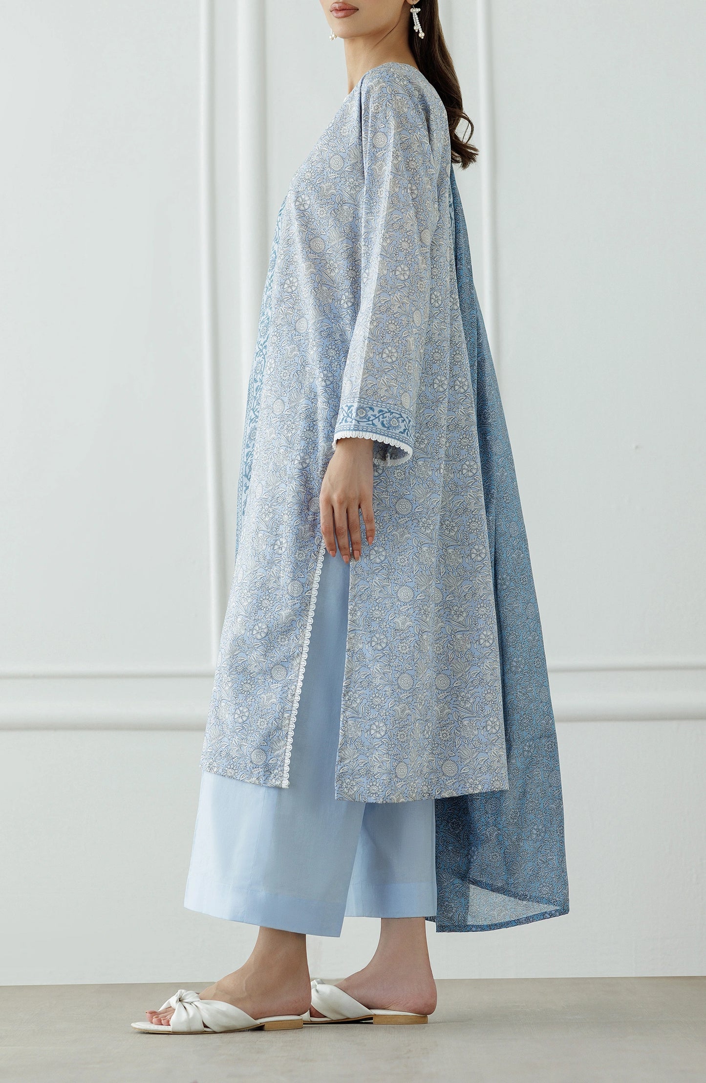 Woman wearing a blue patterned dress with white trim against a dyed trouser. UNSTITCHED Printed Lawn Shirt Dupatta & Pant - 3 Piece Suits - OTL-25-018
