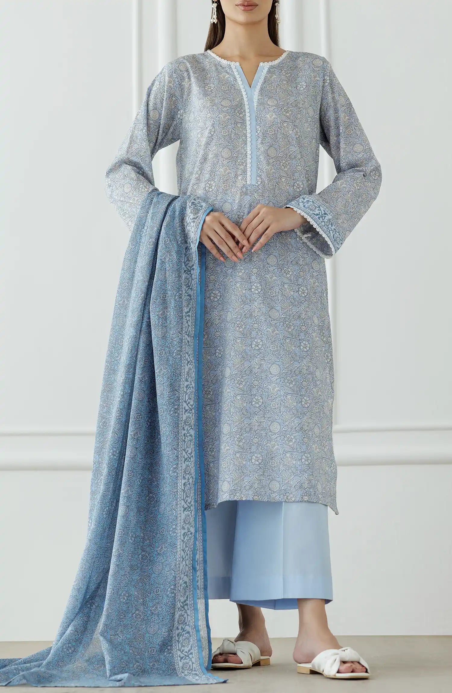 Woman wearing a light gray kurta with blue pants and a matching dupatta against a plain trouser. Stitched Printed Lawn Shirt Dupatta & Pant - 3 Piece Suits - OTL-25-018