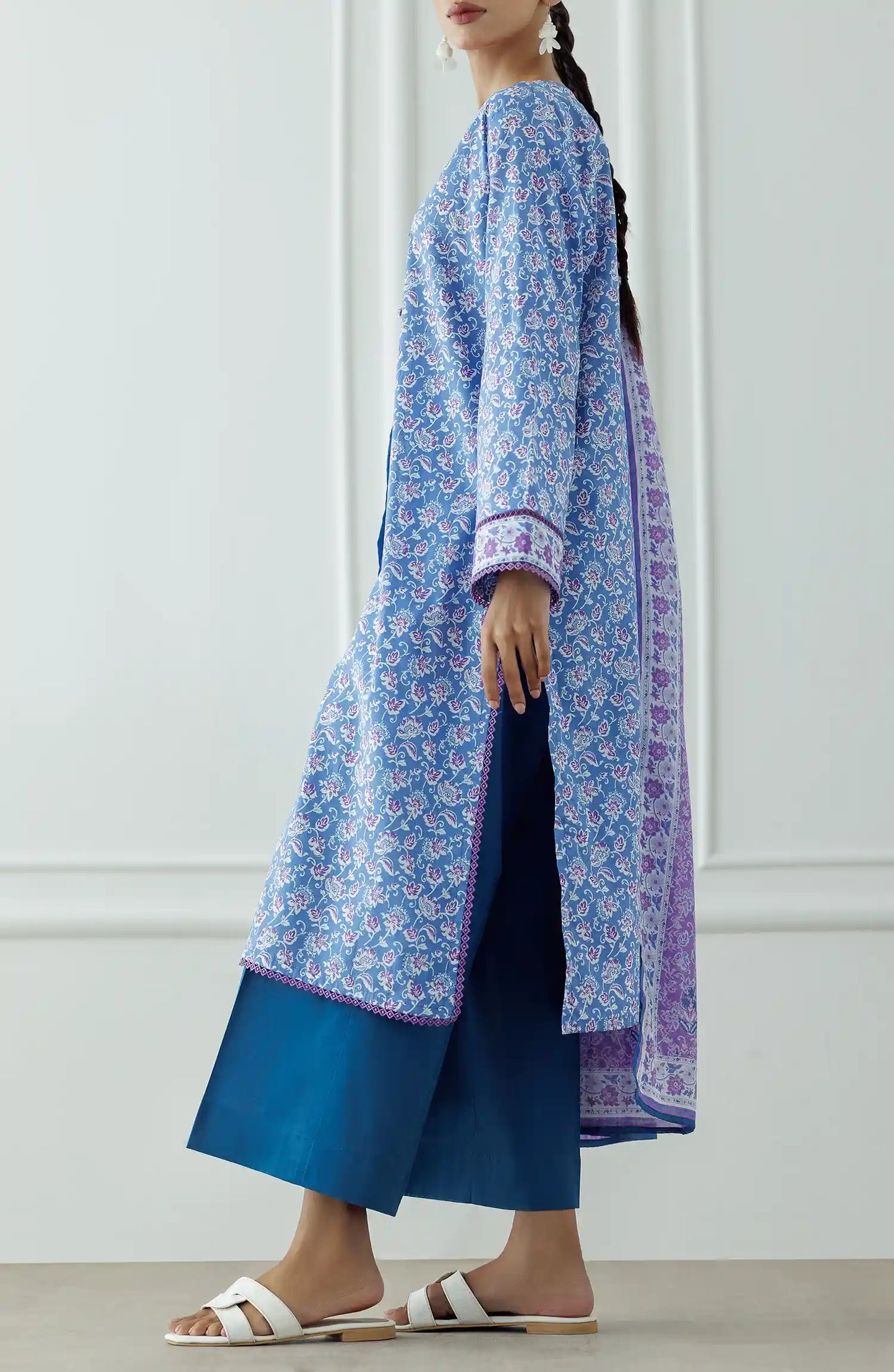 Woman wearing a blue floral kurta with a matching dupatta and blue pants against a plain trouser. Stitched Printed Lawn Shirt Dupatta & Pant - 3 Piece Suits - OTL-25-043
