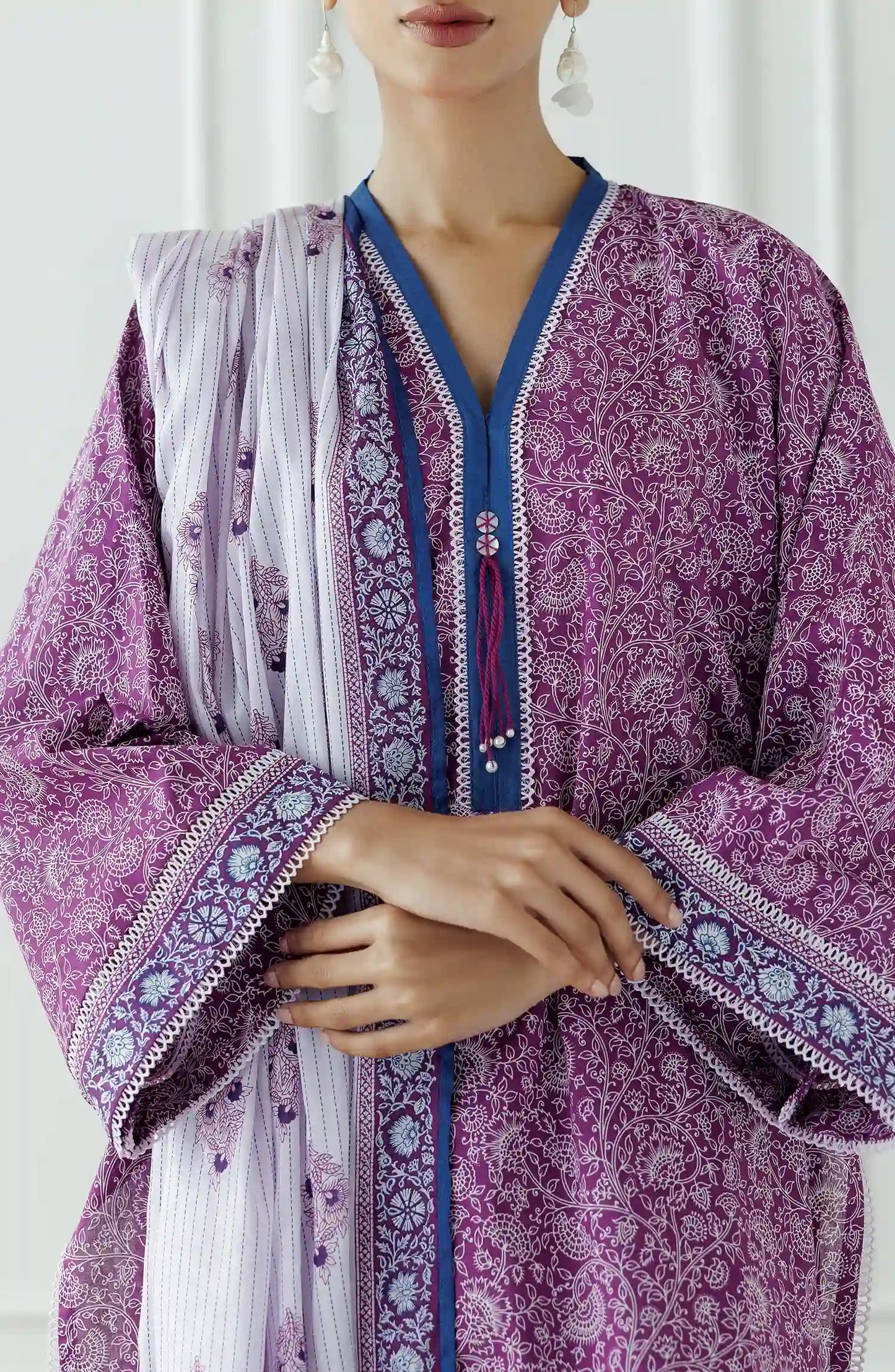 Woman wearing a purple traditional outfit with a white dupatta against a classic traditional shalwar. Stitched Printed Lawn Shirt Dupatta & Pant - 3 Piece - OTL-25-051