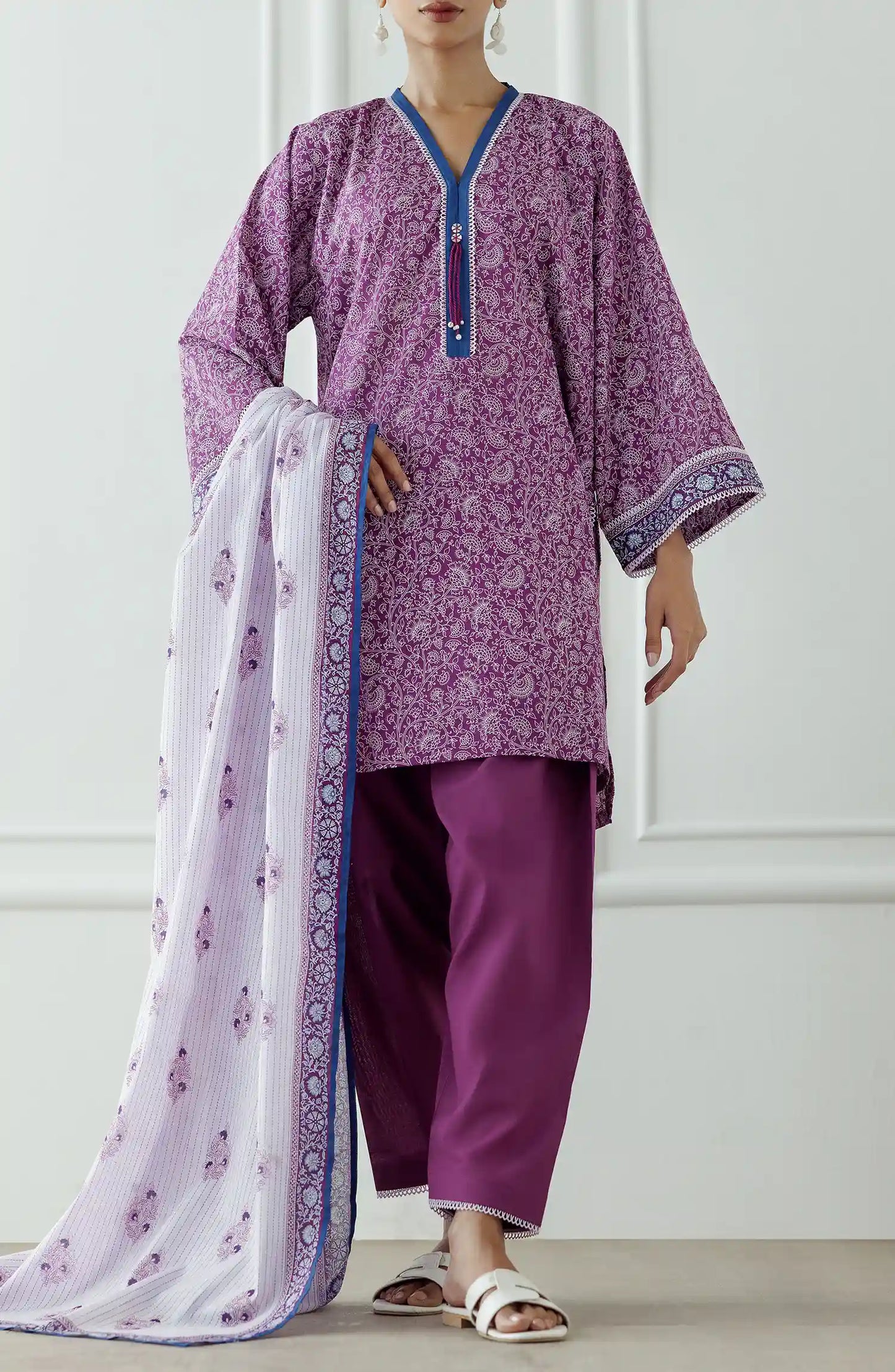 Woman wearing a purple traditional outfit with a white dupatta against a classic traditional shalwar. Stitched Printed Lawn Shirt Dupatta & Pant - 3 Piece - OTL-25-051