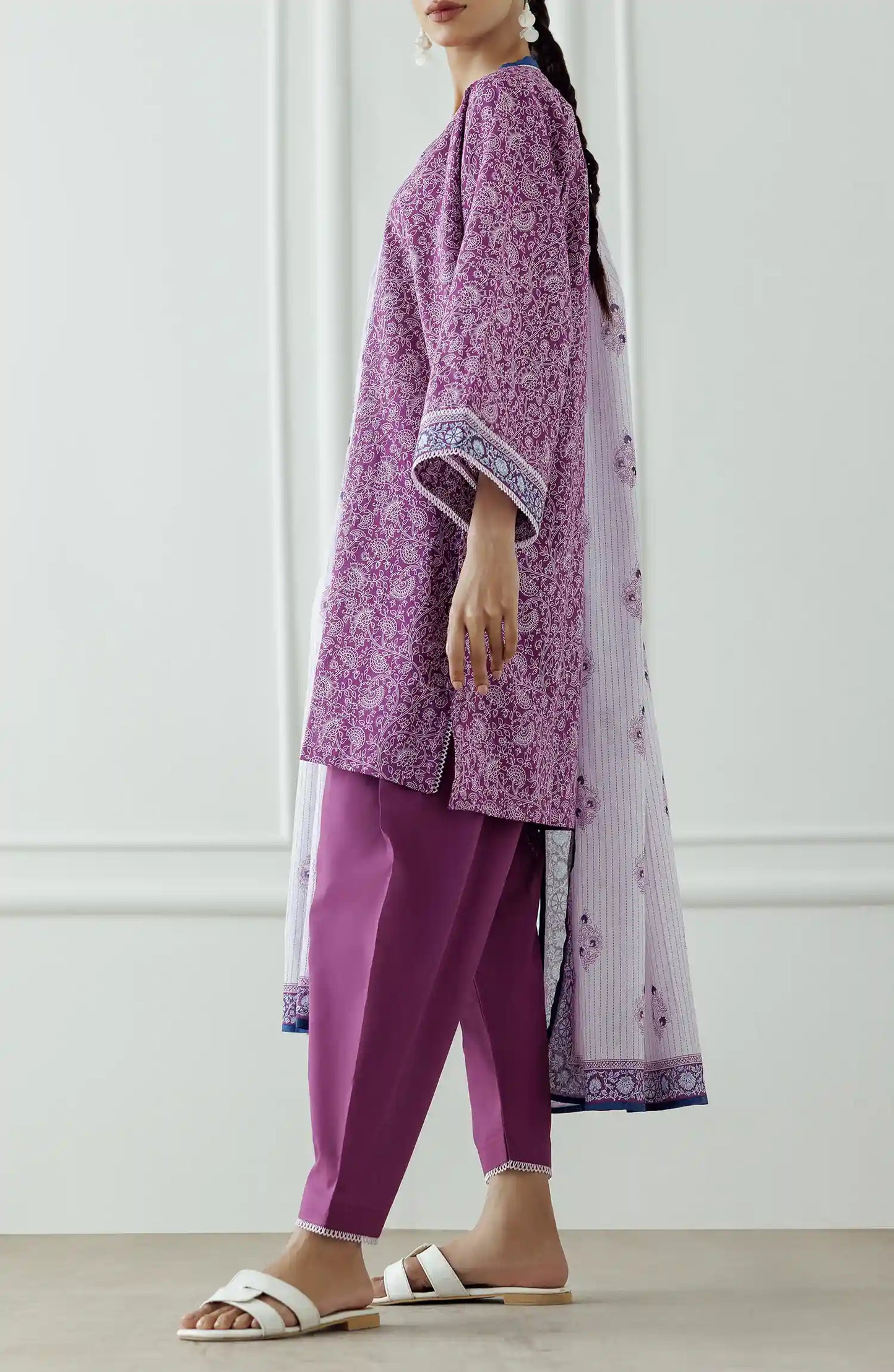 Woman wearing a purple traditional outfit with a white dupatta against a classic traditional shalwar. Stitched Printed Lawn Shirt Dupatta & Pant - 3 Piece - OTL-25-051