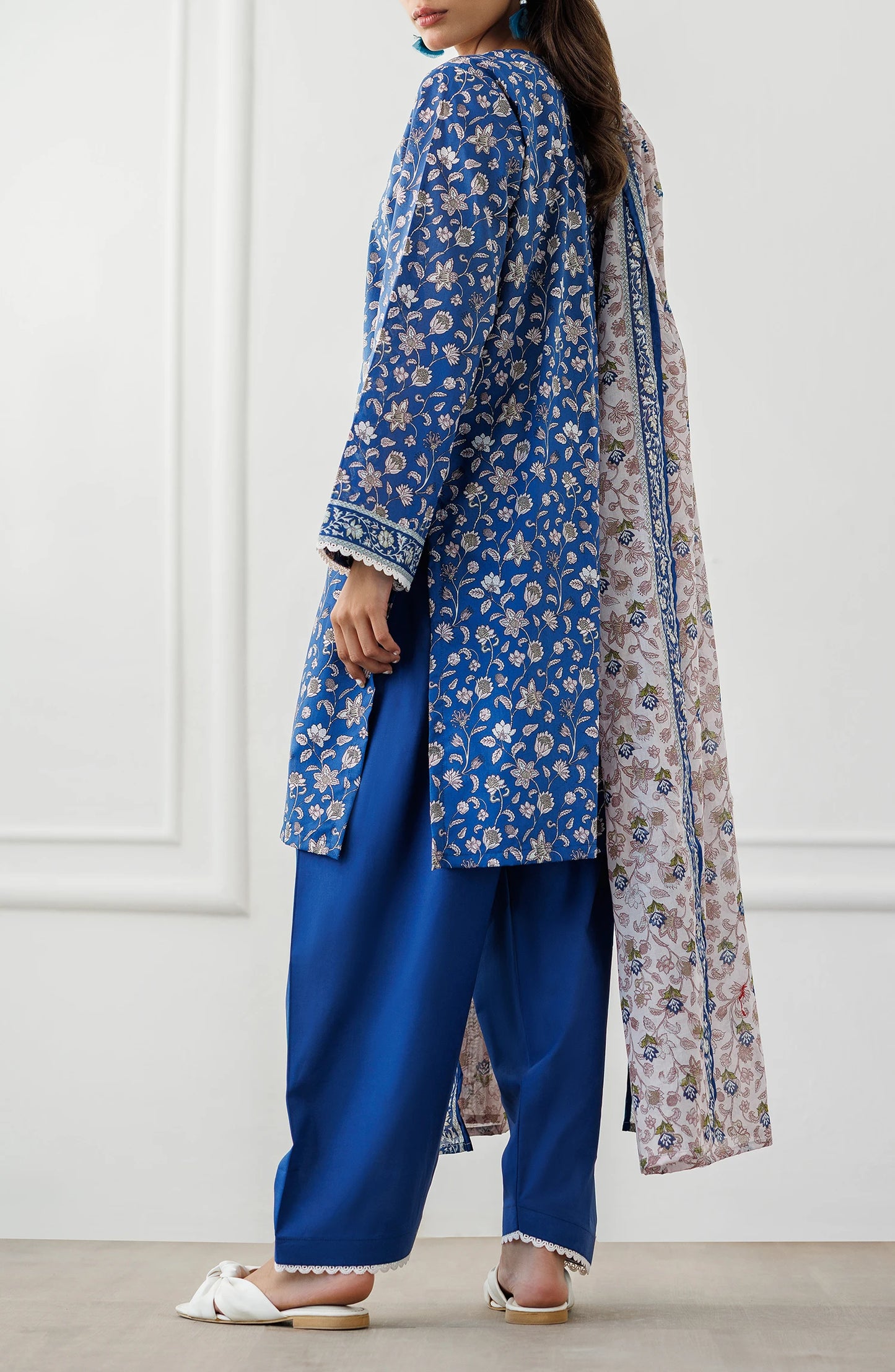 Woman wearing a blue floral kurta with matching pants and a pink dupatta against a dyed shalwar. Stitched Printed Lawn Shirt Dupatta & Pant - 3 Piece Suits - OTL-25-068
