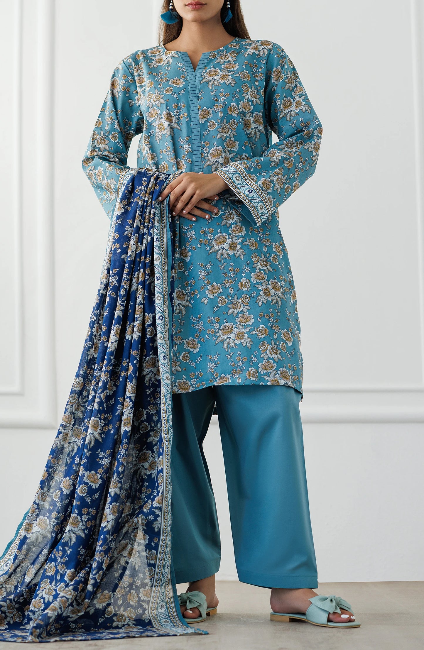 Woman wearing a blue floral outfit with matching dupatta against a plain trouser. Unstitched Printed Lawn Shirt Dupatta & Pant - 3 Piece Suits - OTL-25-070