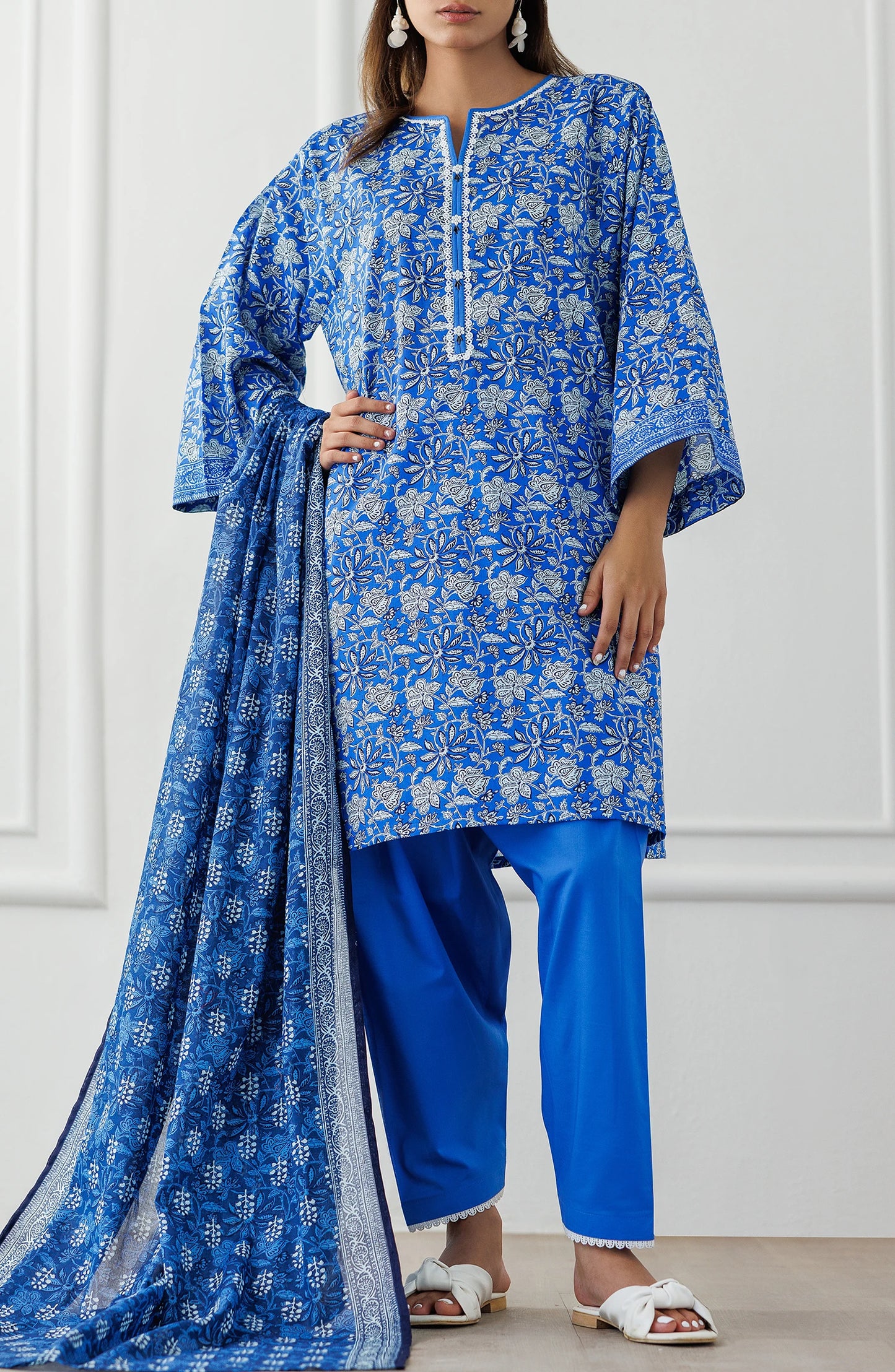 Woman wearing a blue floral kurta with matching pants and dupatta against a dyed shalwar. Unstitched Printed Lawn Shirt Dupatta & Pant - 3 Piece Suits - OTL-25-100