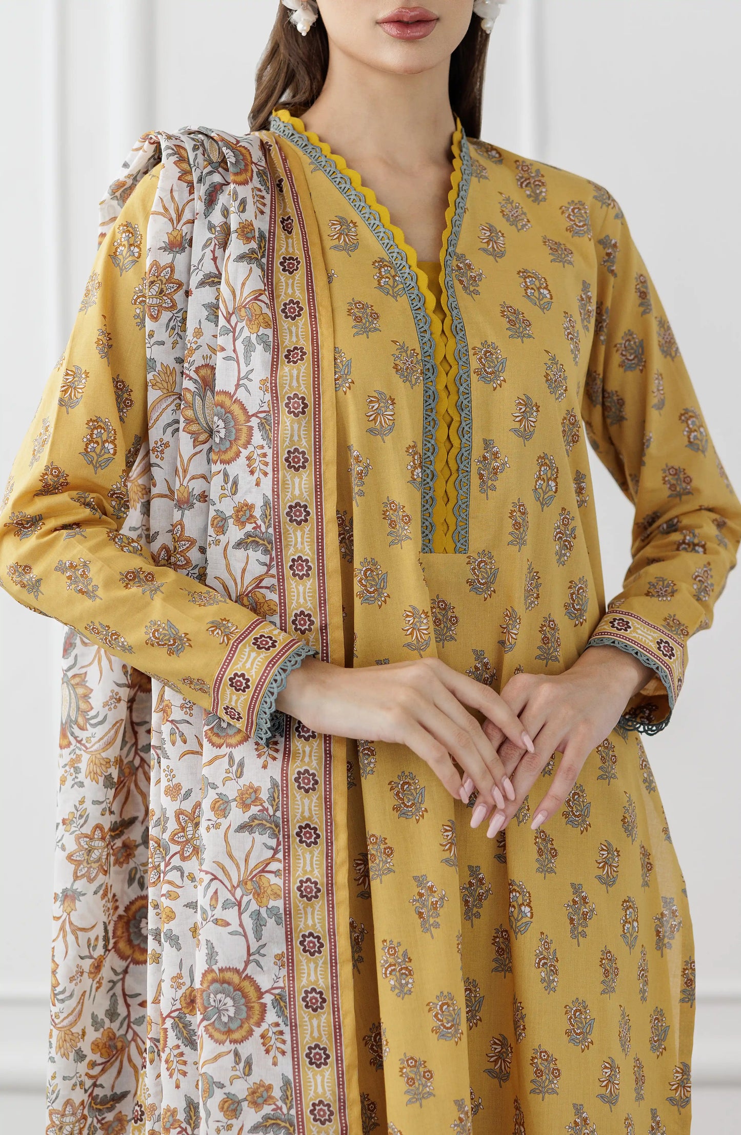 Woman wearing a mustard yellow floral dress with a matching dupatta on a plain trouser. Stitched Printed Lawn Shirt Dupatta & Pant - 3 Piece Suits - OTL-25-118