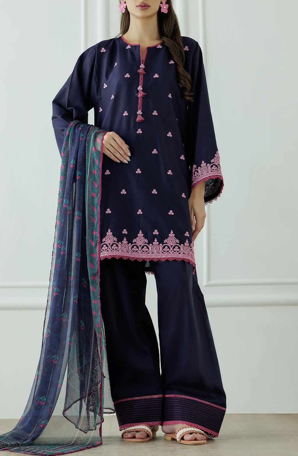 Woman wearing a navy blue traditional outfit with pink patterns, holding a matching dupatta and dyed trouser. Stitched Luxury Premium Embroidered Lawn Shirt Dupatta & Pant - 3 Piece Suits - OTL-25-132