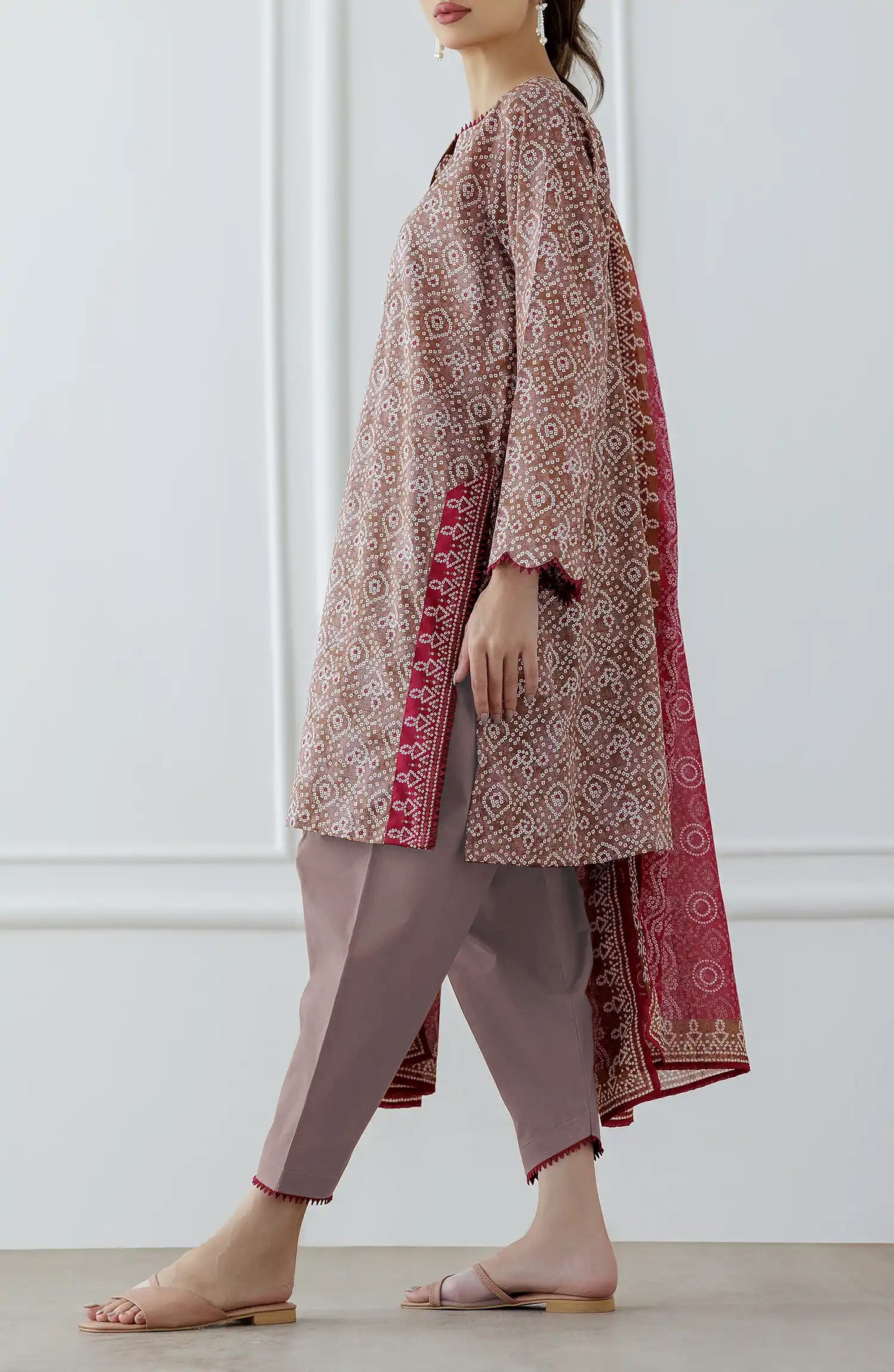 Woman wearing a patterned kurta with pants and a pink dupatta against a dyed trouser. Stitched Printed Lawn Shirt Dupatta & Pant - 3 Piece - OTL-25-308. 