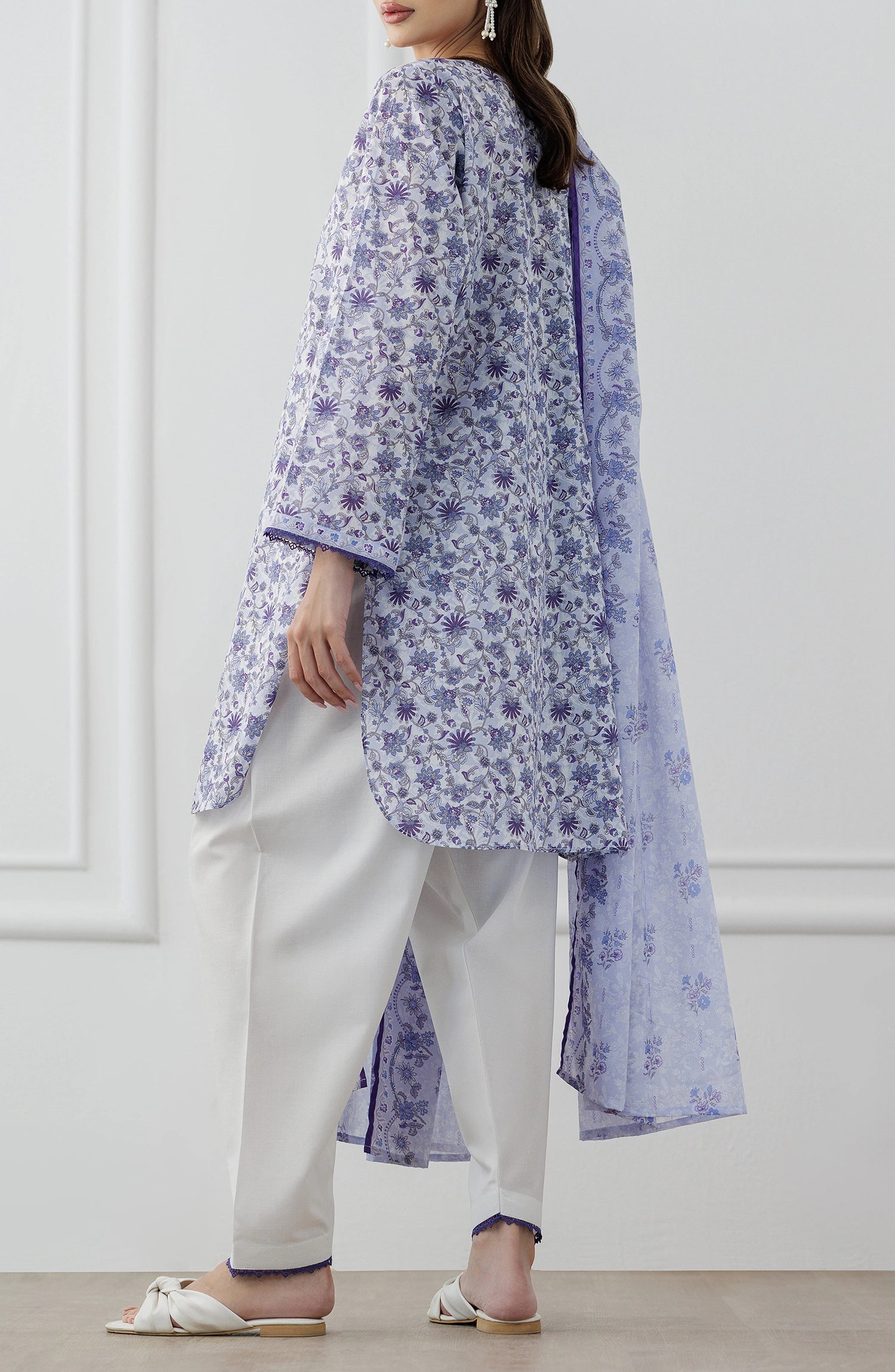 Woman wearing a blue and white floral outfit with a matching dupatta against a dyed trouser. Unstitched Printed Lawn Shirt Dupatta & Pant - 3 Piece Suits - OTL-25-312