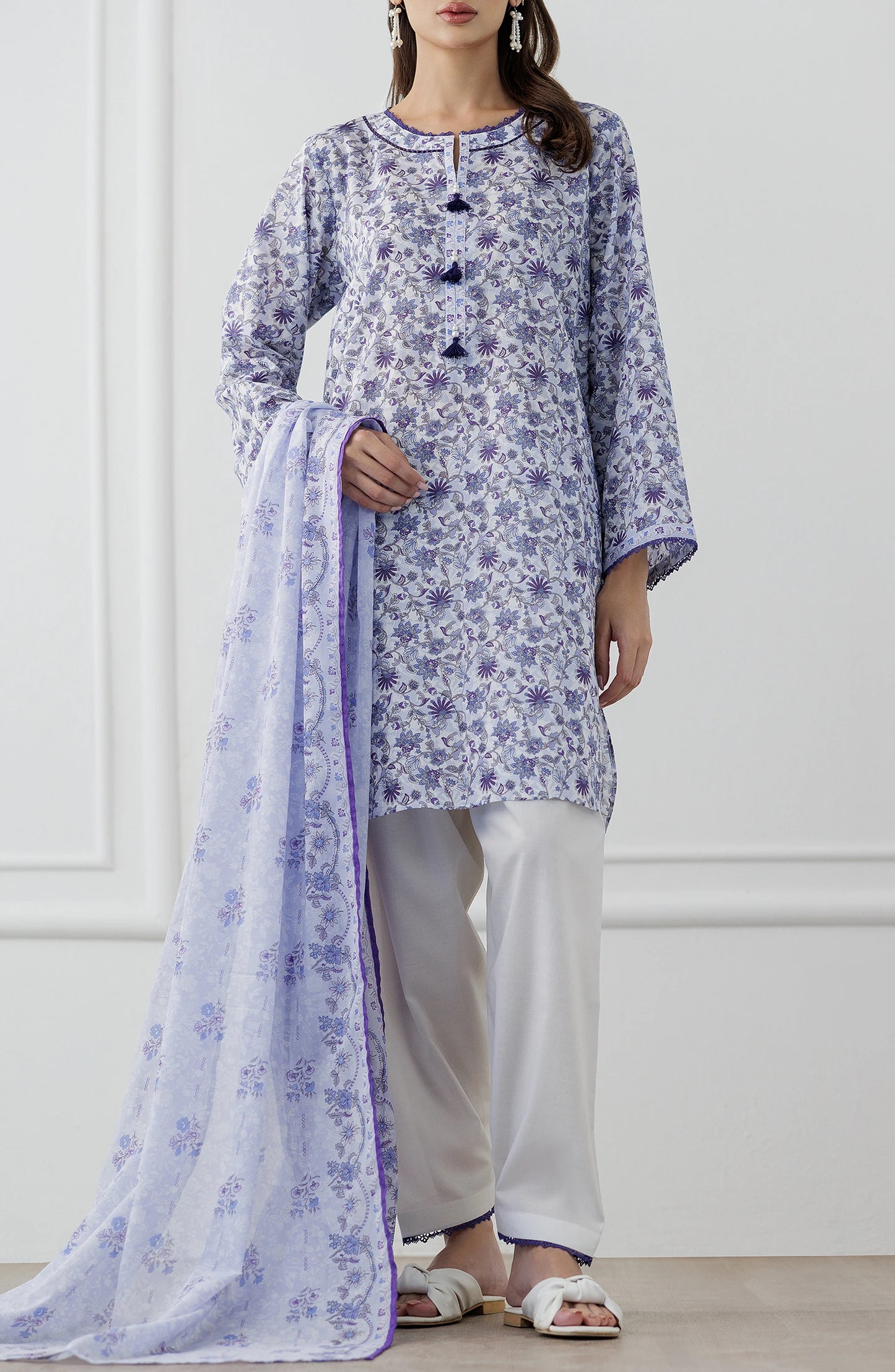 Woman wearing a blue and white floral outfit with a matching dupatta against a dyed trouser. Unstitched Printed Lawn Shirt Dupatta & Pant - 3 Piece Suits - OTL-25-312