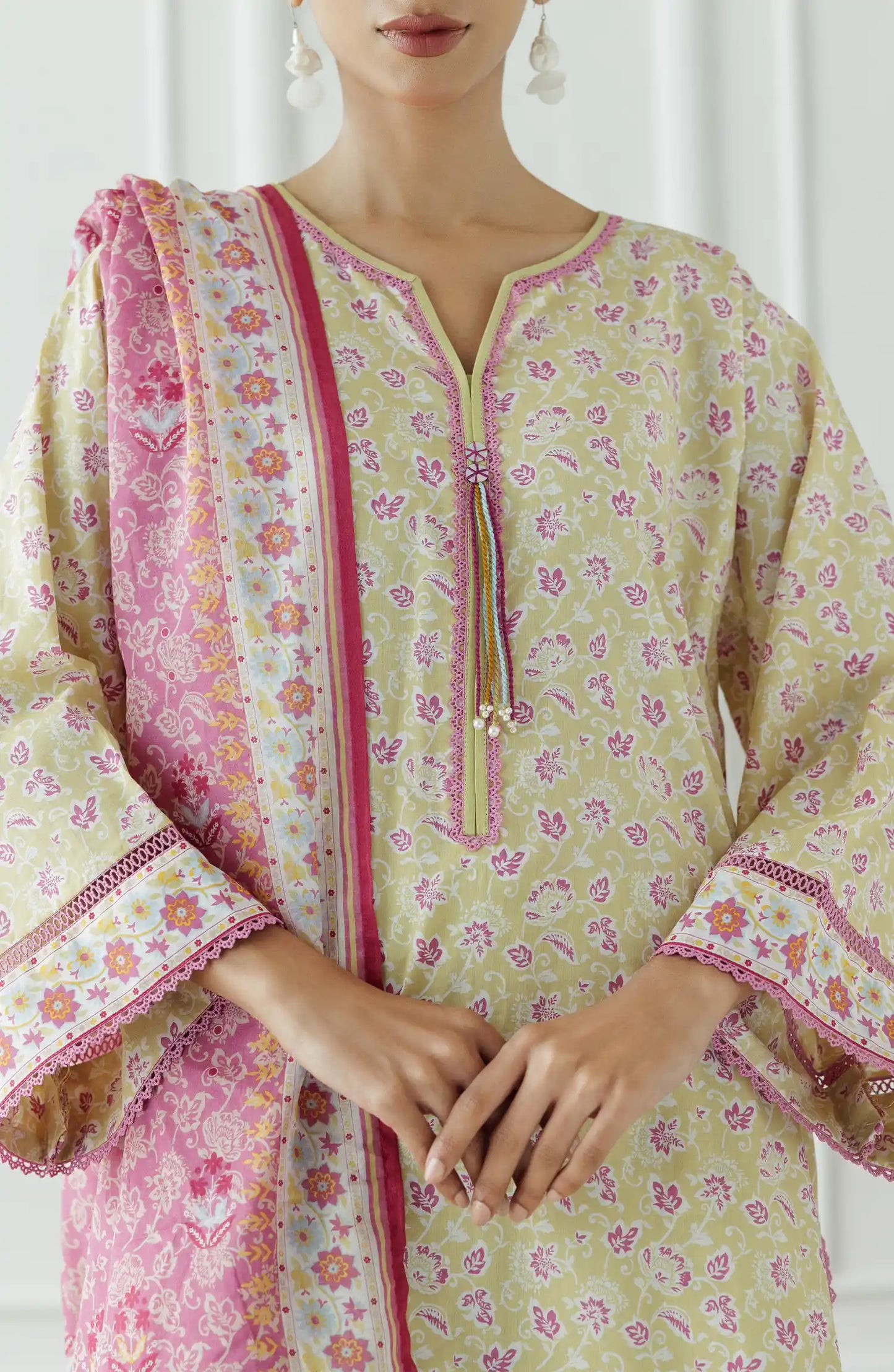 Woman wearing a traditional outfit with a floral kurta, pants, and pink dupatta against a plain trouser. Stitched Printed Lawn Shirt Dupatta & Pant - 3 Piece Suits - OTL-25-330