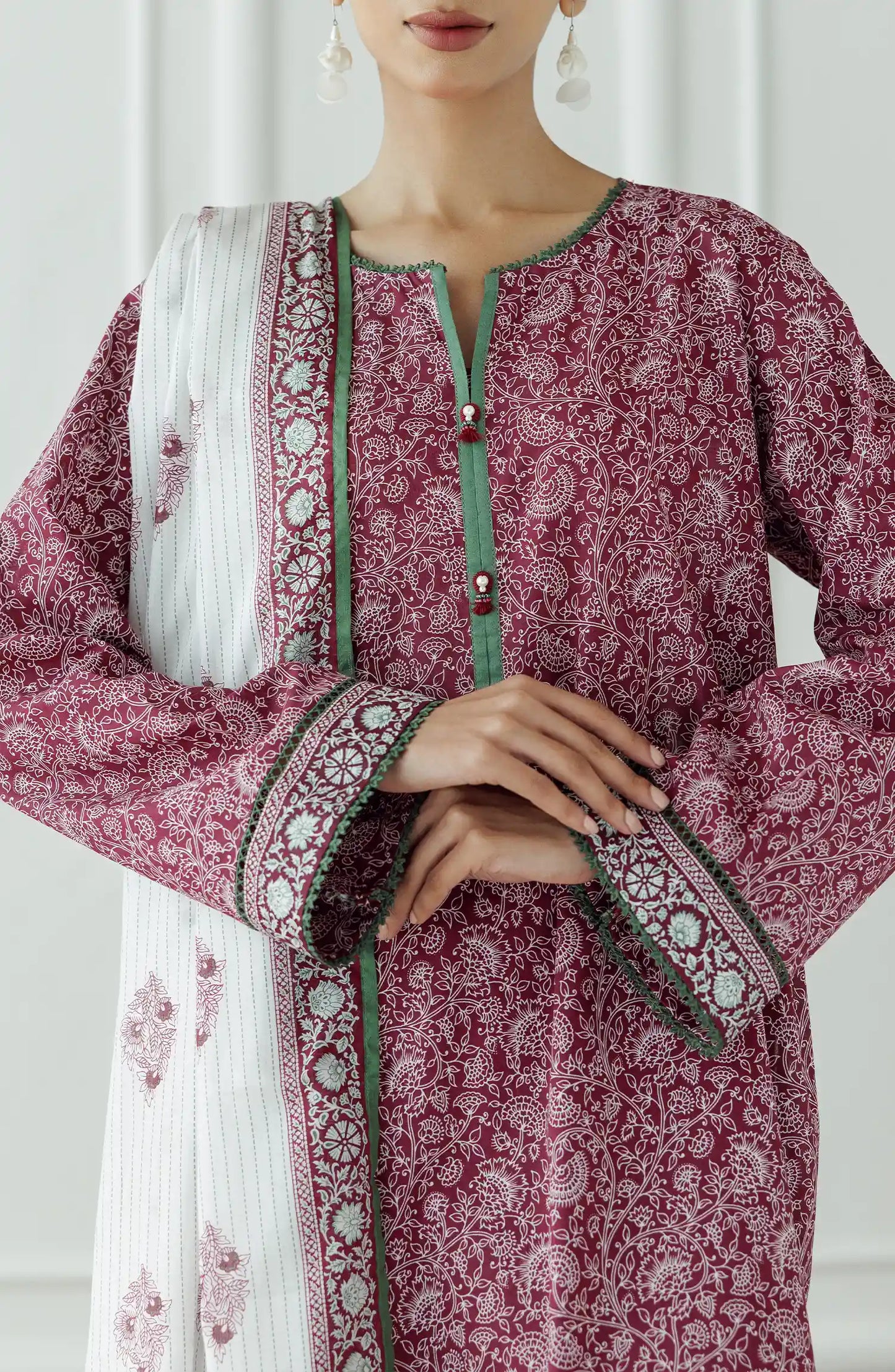 Woman wearing a pink floral kurta with white pants and a matching dupatta against a plain dyed trouser. Stitched Printed Lawn Shirt Dupatta & Pant - 3 Piece - OTL-25-333. 