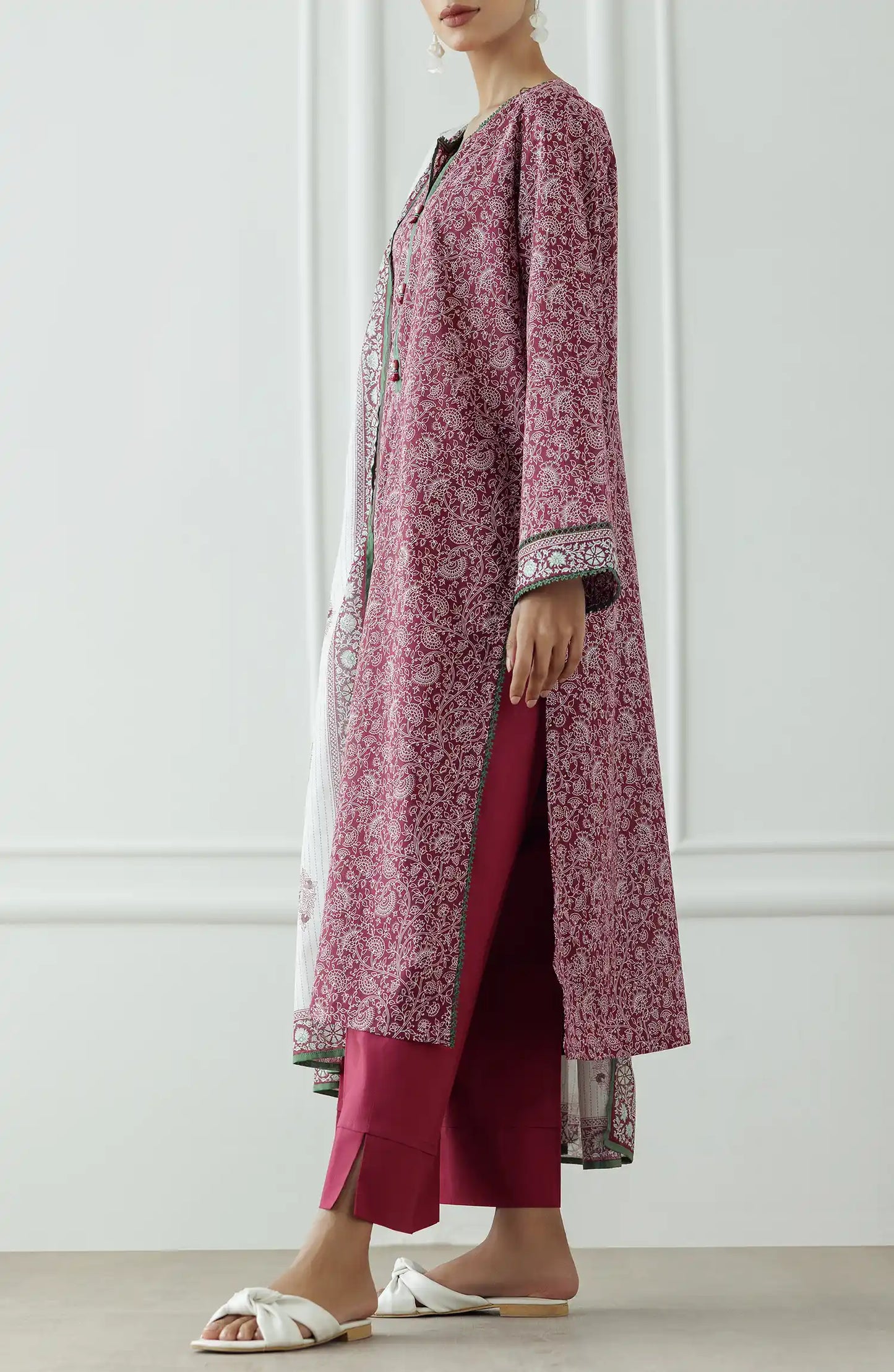Woman wearing a pink floral kurta with white pants and a matching dupatta against a plain dyed trouser. Stitched Printed Lawn Shirt Dupatta & Pant - 3 Piece - OTL-25-333. 