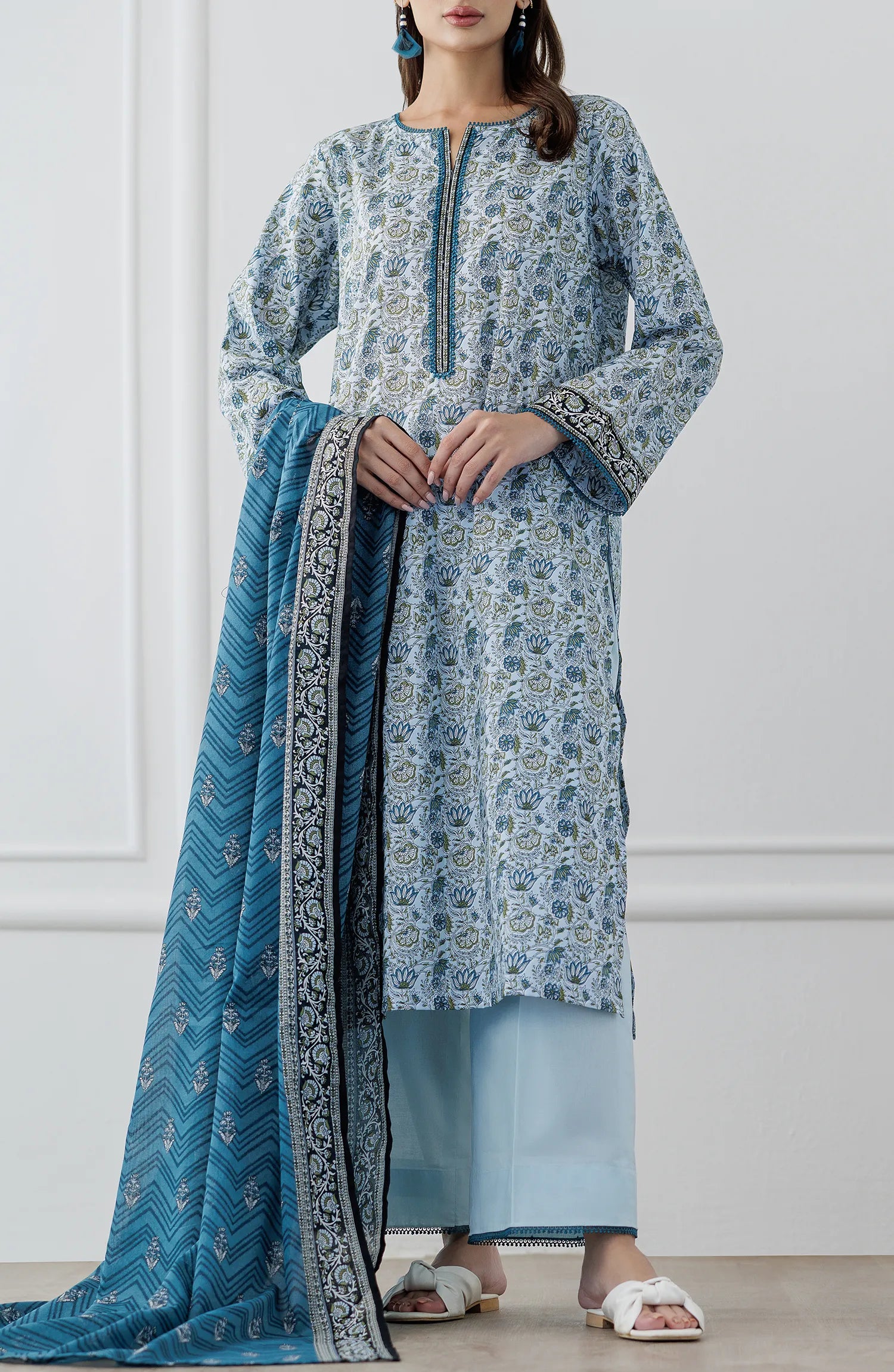 Woman wearing a blue and white patterned kurta with a matching dupatta on a dyed trouser. Stitched Printed Lawn Shirt Dupatta & Pant - 3 Piece Suits - OTL-25-347