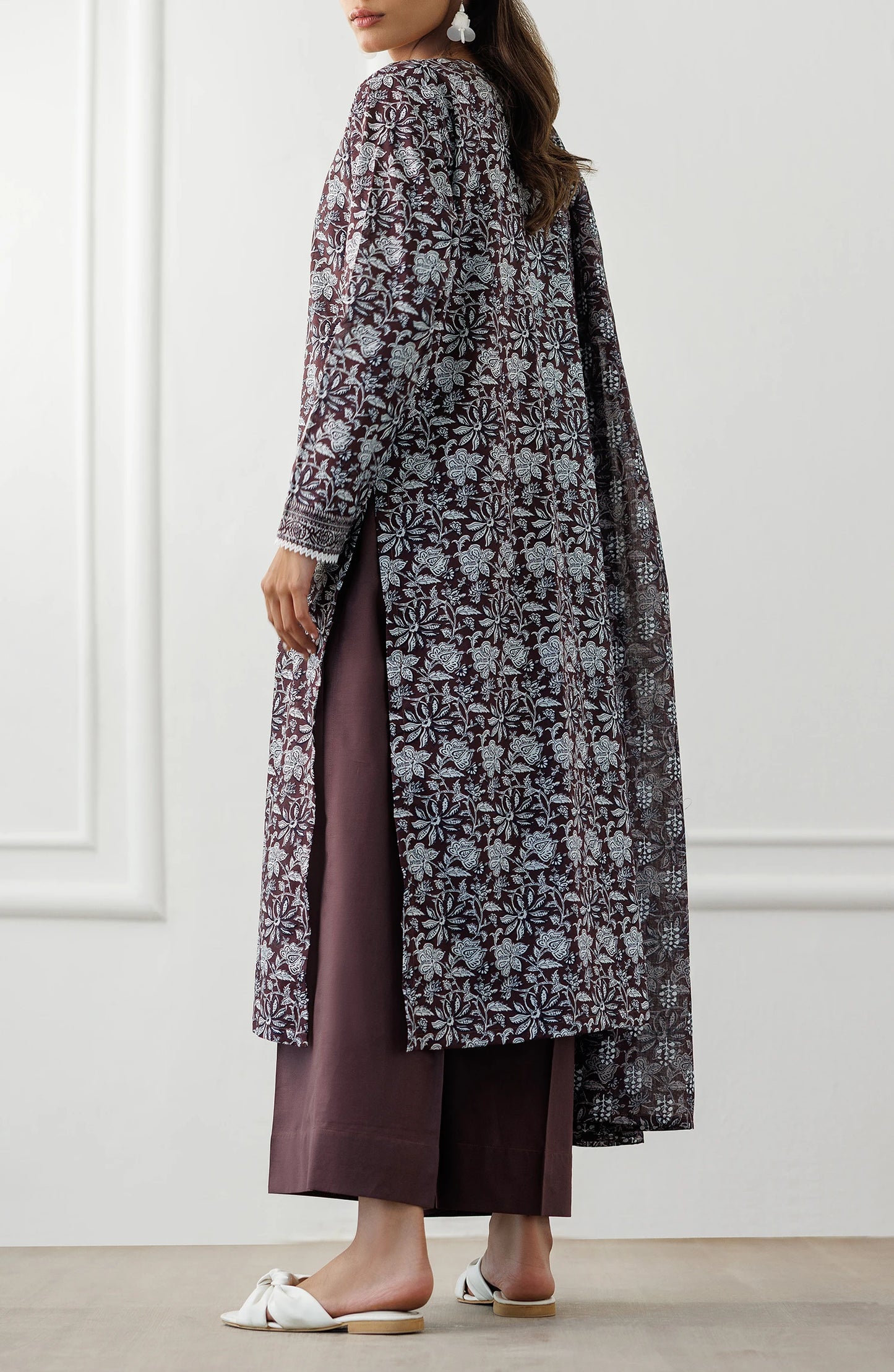 Woman wearing a long floral dress with a matching dupatta against a plain trouser. Stitched Printed Lawn Shirt Dupatta & Pant - 3 Piece Suits - OTL-25-371