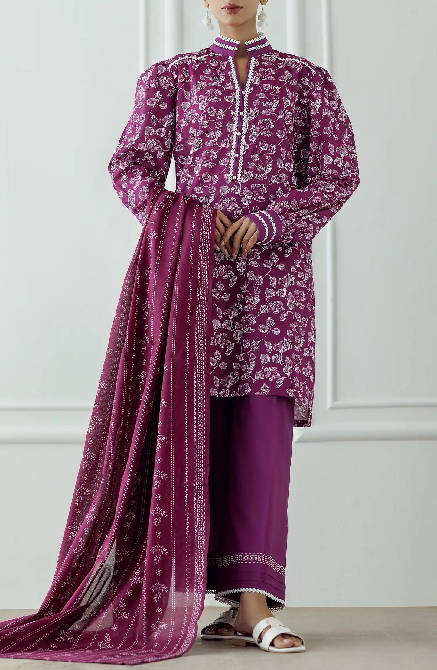 Women wearing a purple dress with white floral pattern and pearl details and dyed trouser. Stitched Printed Lawn Shirt Dupatta & Pant - 3 Piece Suits - OTL-25-378
