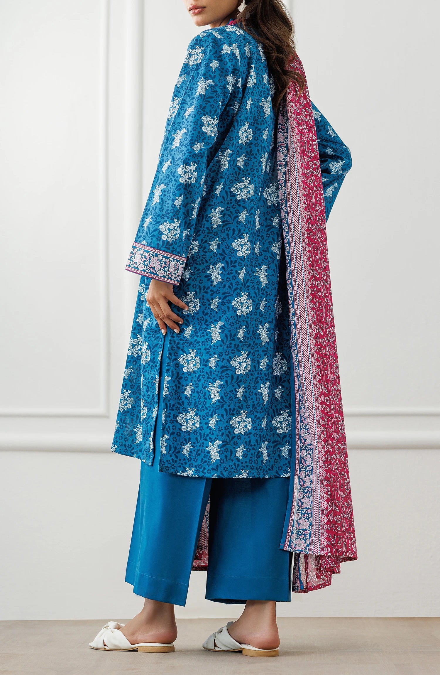 Woman wearing a blue floral dress with a pink dupatta against a matching trouser. Unstitched Printed Lawn Shirt Dupatta & Pant - 3 Piece Suits - OTL-25-477
