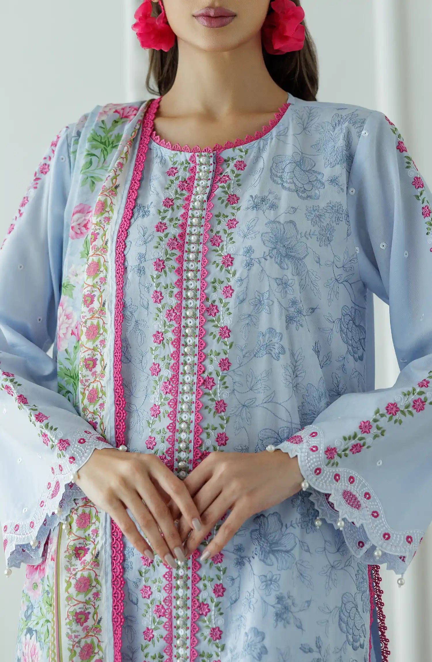 Woman wearing a light blue embroidered outfit with a floral dupatta against a dyed trouser. Stitched Luxury Premium Embroidered Lawn Shirt Dupatta & Pant - 3 Piece Suits - WRC25S-3008