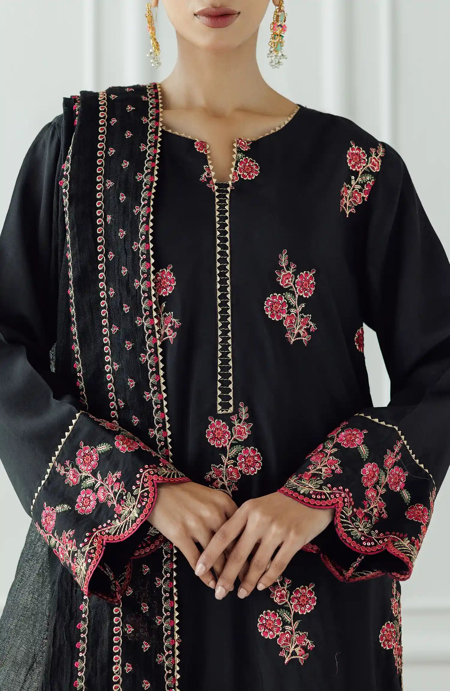 Women wearing a Black embroidered dress with pink floral patterns on a dyed trouser. Stitched Luxury Festive Formal Raw Silk Shirt Dupatta & Pant - 3 Piece Suits - WRFR24S-3017