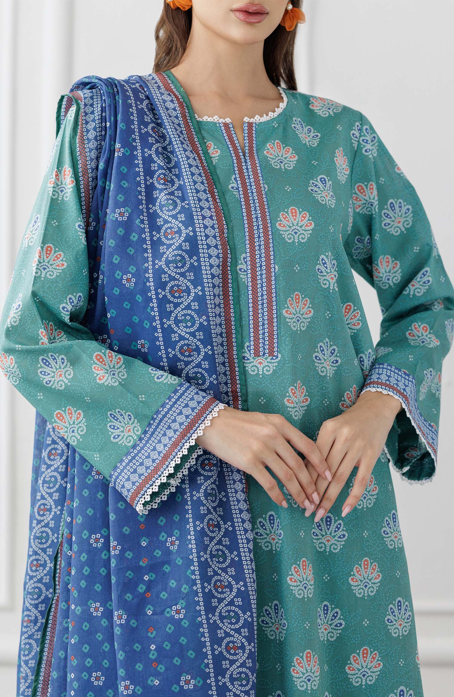 UNSTITCHED Printed Lawn Shirt Dupatta & Pant - 3 Piece Suits - OTL-25-307. Woman wearing a teal traditional outfit with a blue dupatta against a dyed trouser.
