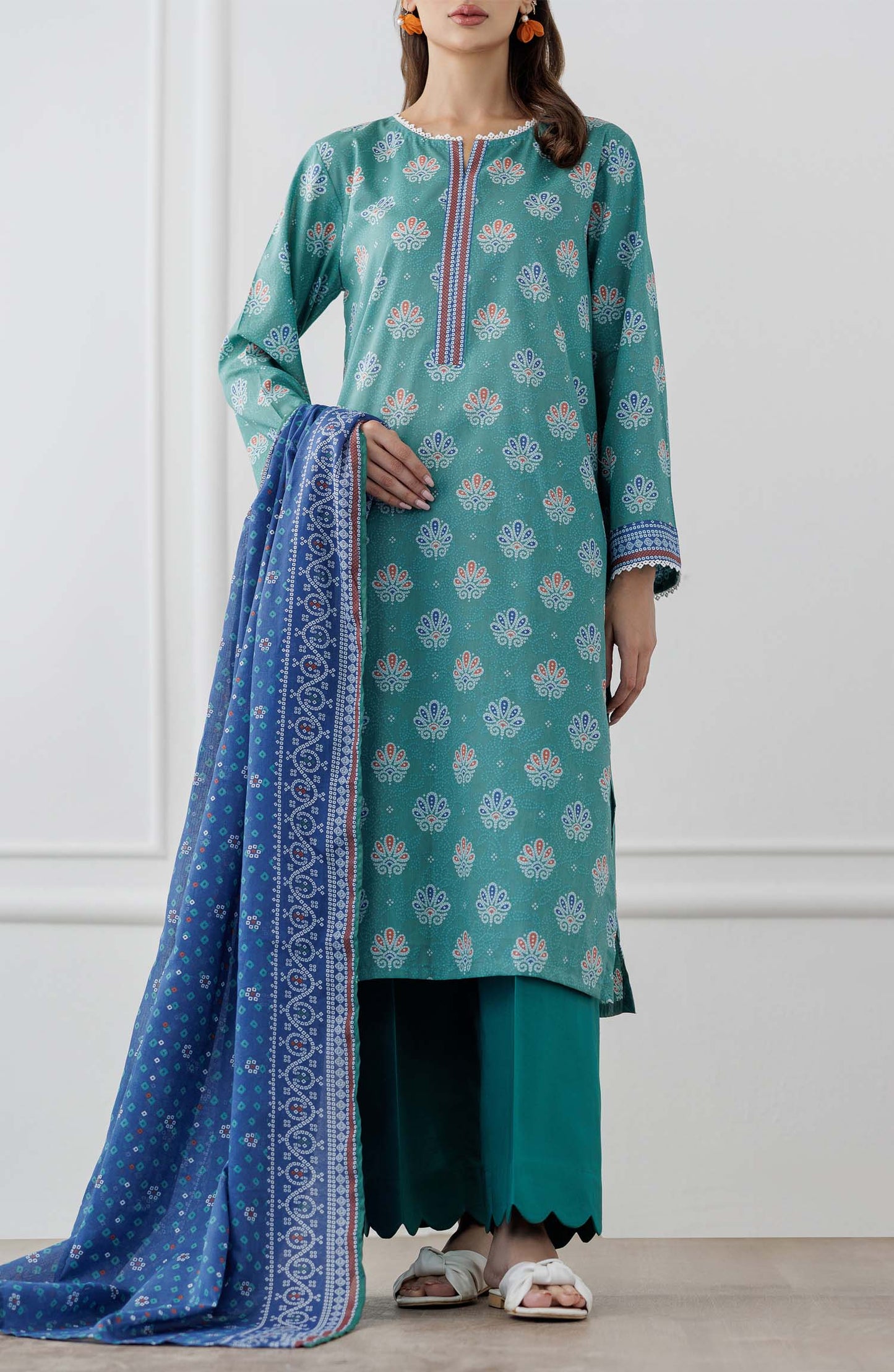 UNSTITCHED Printed Lawn Shirt Dupatta & Pant - 3 Piece Suits - OTL-25-307. Woman wearing a teal traditional outfit with a blue dupatta against a dyed trouser.